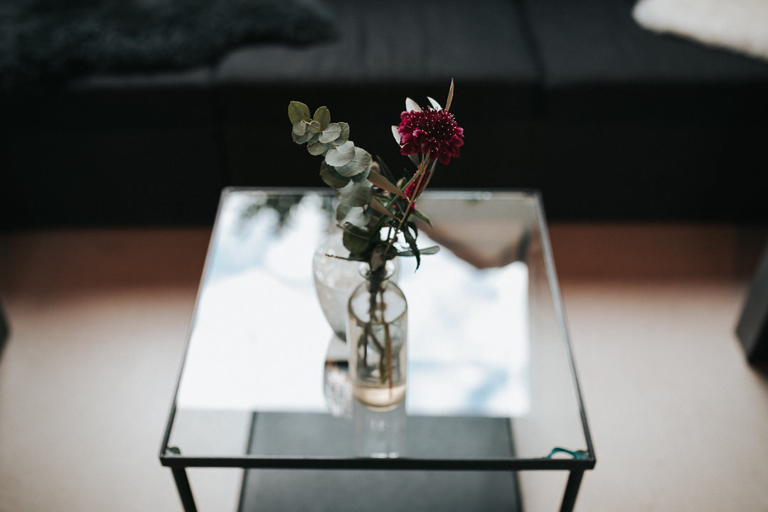 Glastisch mit Blumenstrauß.