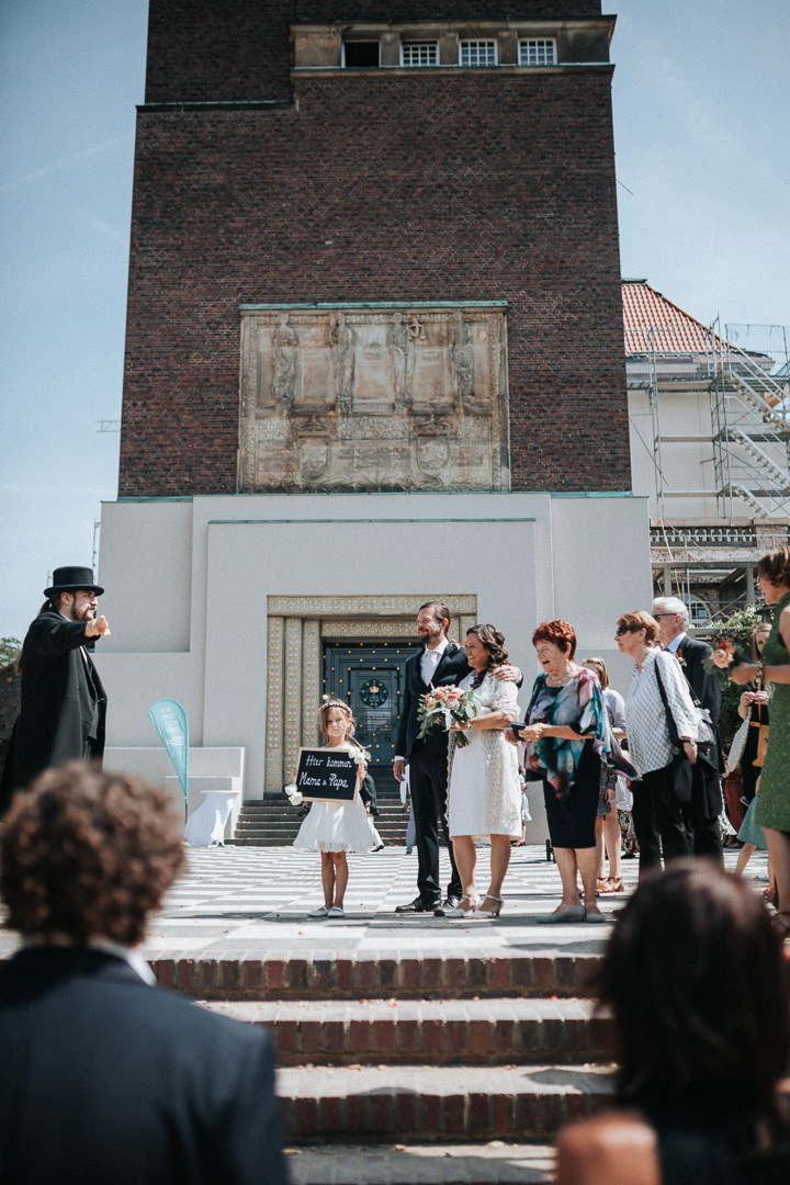 Hochzeitsgesellschaft wird vom Hochzeitsbutler vor dem Hochzeitsturm in Darmstadt in Empfang genommen