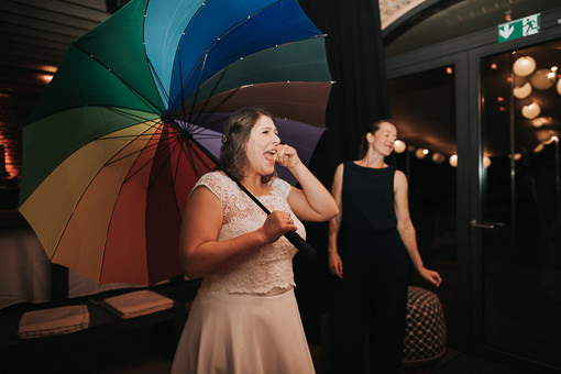 Braut mit Regenbogenregenschirm