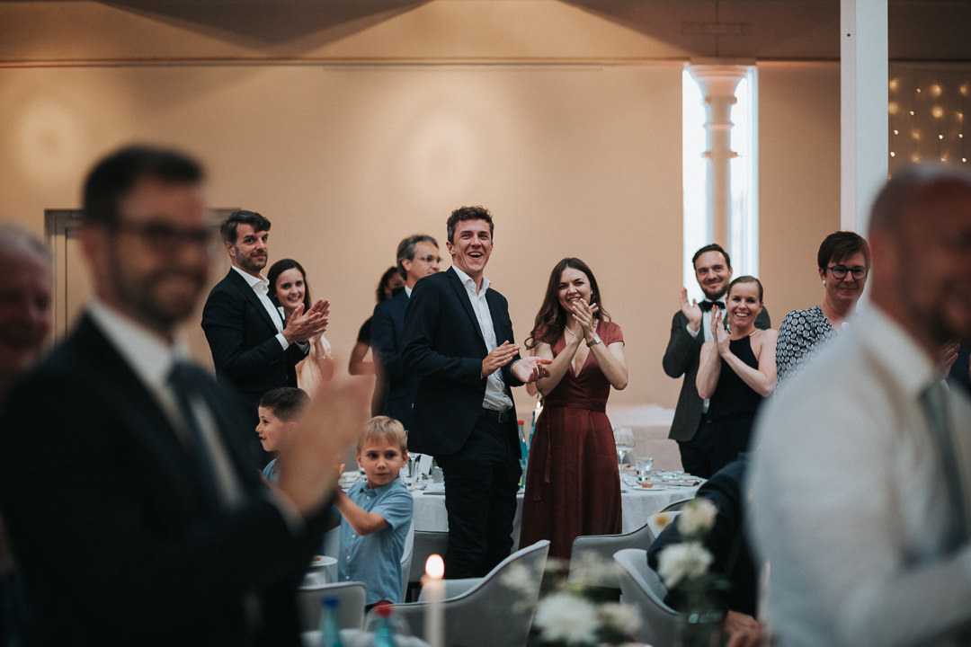 Hochzeitsgäste applaudieren dem Brautpaar zu