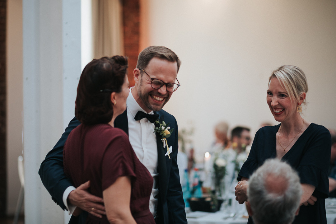 Bräutigam lacht mit seinen Gästen zusammen