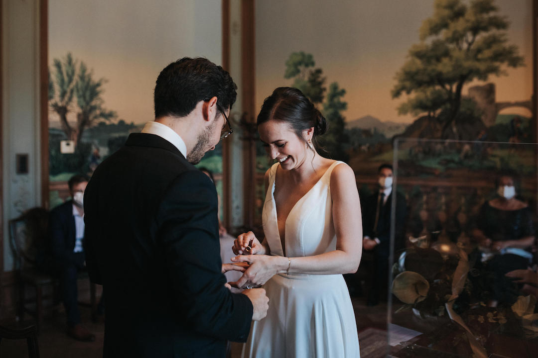 Braut steckt dem Bräutigam den Ring an den Finger