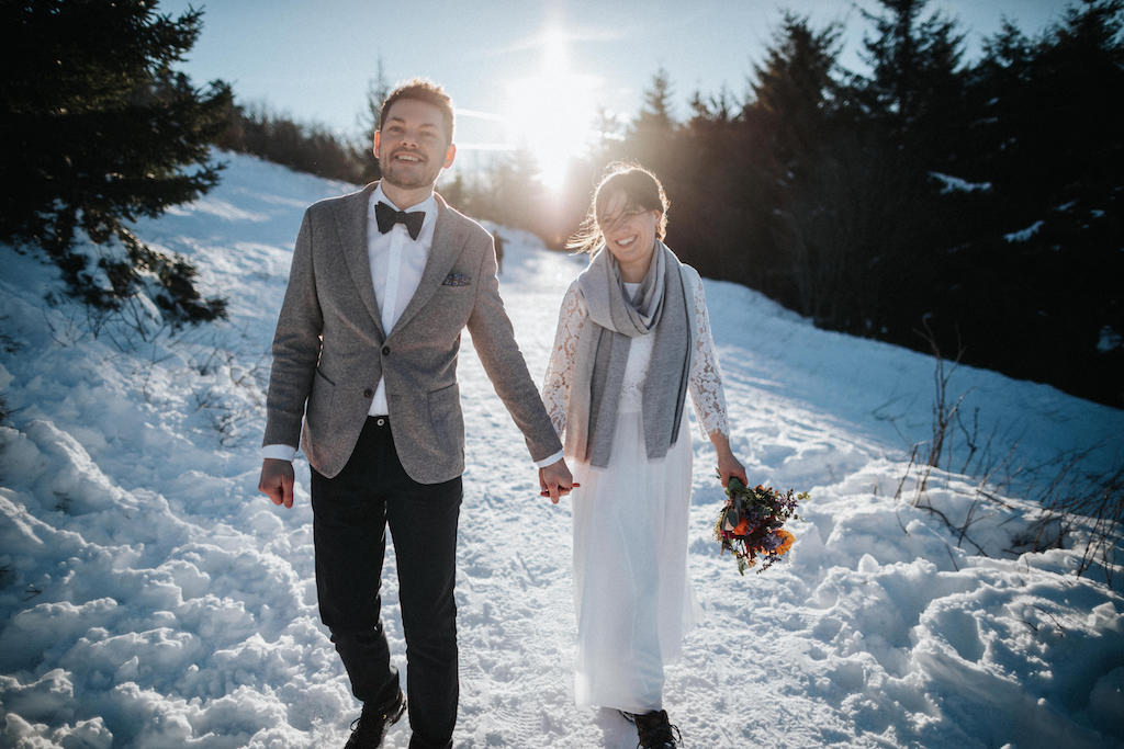 Braut und Bräutigam spazieren durch den Schnee auf dem Feldberg im Taunus