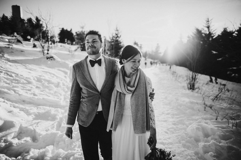 Brautpaar läuft gemeinsam durch den Schnee auf dem Feldberg im Taunus