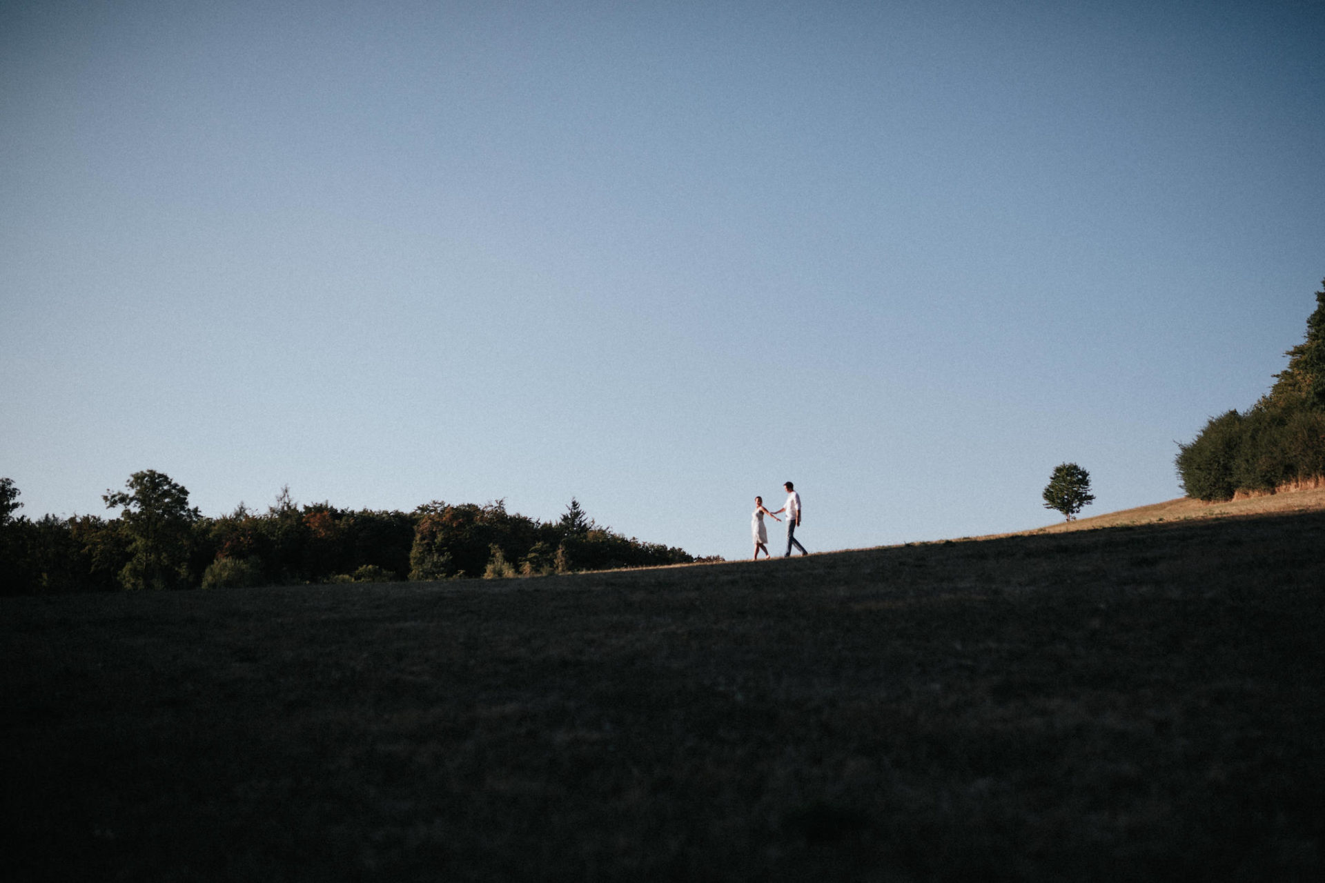 Paar läuft einen Hügel herab.