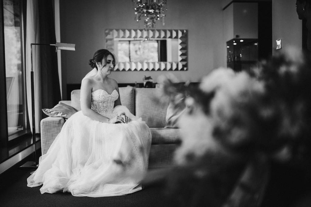 Braut sitzt kurz vor der Trauung auf einer Couch.