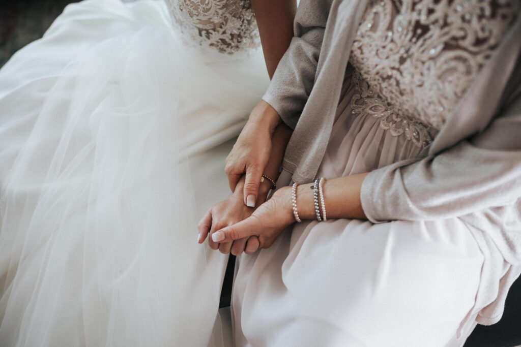 Brautmutter hält die Hand der Braut