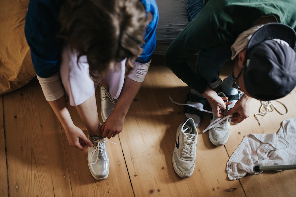 Trauzeugin mit ihrem Partner bindet sich die Schuhe